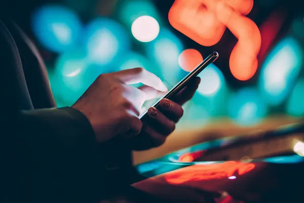 A glamorous woman holding casino chips in a neon-lit environment, representing the premium online casino atmosphere of BETPH7.